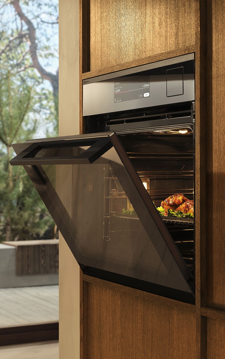 Félig nyitott beépített sütő fa konyhában.