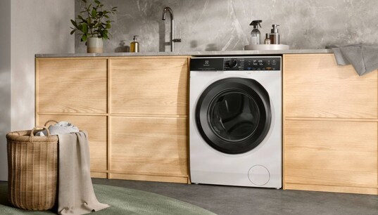 A washer dryer placed below a counter in a laundry room